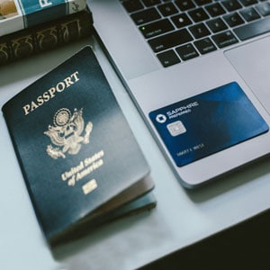 Personal items including US passport, laptop, and credit card neatly arranged on a desk - Driggs Immigration Law