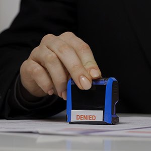 Immigration officer stamping a family-based visa application as denied in Harris County, TX