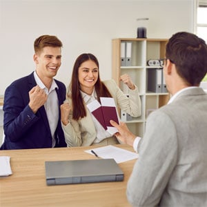 Couple celebrating visa approval with lawyer in Texas office.
